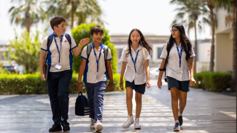 Four young students walking to school.
