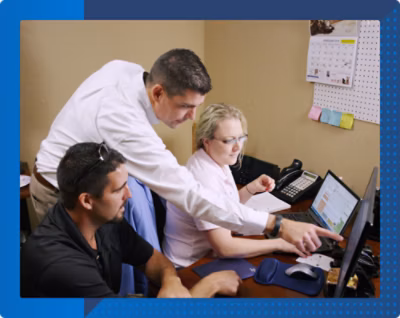 A group of people looking at a computer screen.