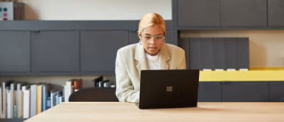 A woman in a white coat using a laptop.
