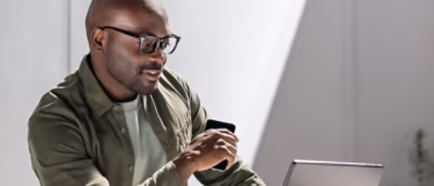 A man wearing glasses looking at a computer.