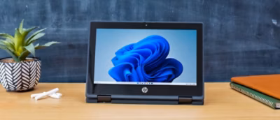 A laptop on a table with a blue object displayed on the screen.