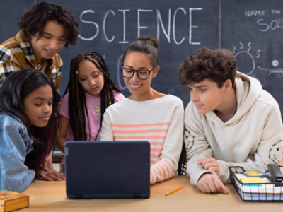 A group of people looking at a laptop.